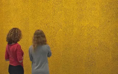 Femmes observant un tableau de la collection Infinity Nets de Yayoi Kusama