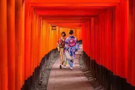 Les femmes en kimonos traditionnels japonais marchant à Fushimi Inari à Kyoto, au Japon