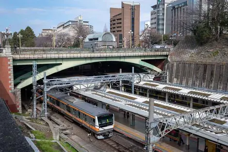 Yotsuya-mitsume Bridge (part of Shinjuku-dori Avenue) over Yotsuya Station, with Kojimachi Exit on far side of road