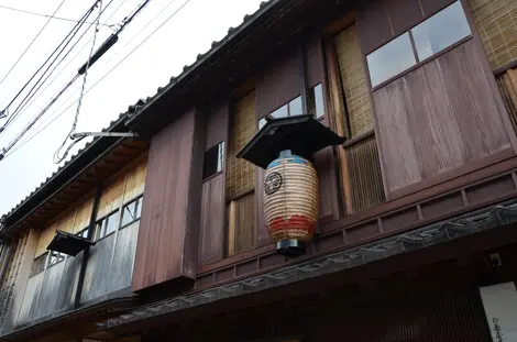 La façade feutrée d'une machiya ornée d'une lanterne